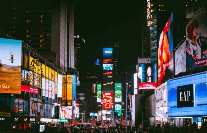 Illuminated billboards and bustling crowds at iconic Times Square, NYC, during the night.