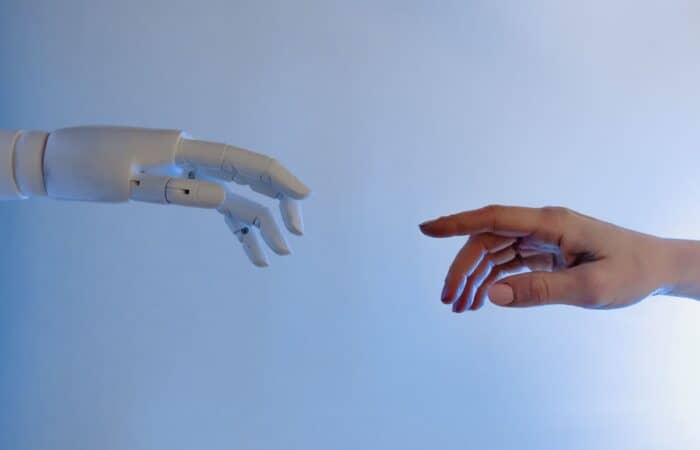 A human hand reaching towards a robotic hand symbolizing technology and connection.